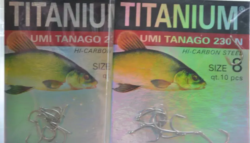 Dwa opakowania haczyków wędkarskich "TITANIUM UMI TANAGO 230N" z wizerunkiem karasia.